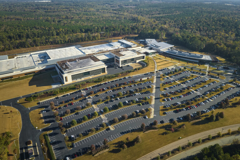 Aerial view of many employee cars parked in parking lot of Ohio industrial manufacturing headquarters.
