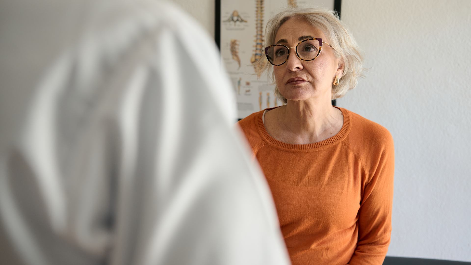 Woman sitting at doctor's office listening to doctor